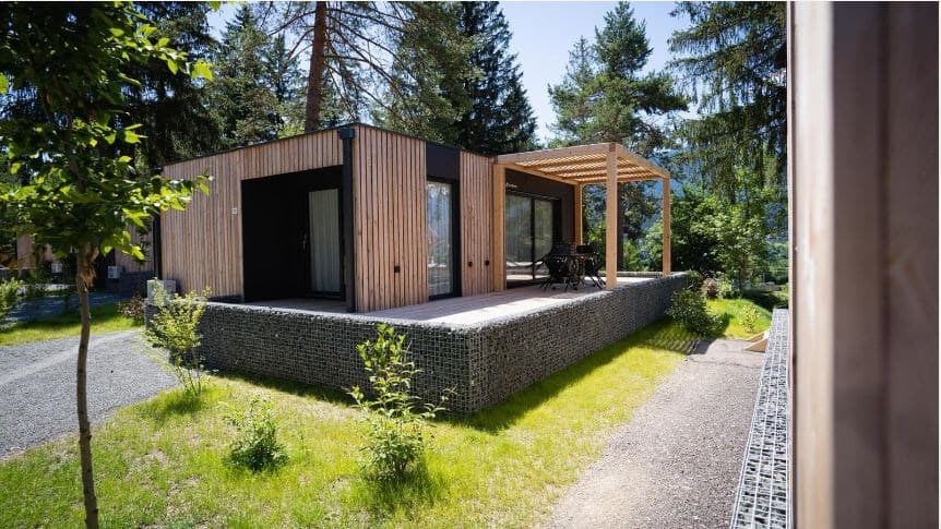 Moderne vakantiewoning met houten gevel, terras en groene omgeving bij EuroParcs Pressegger See