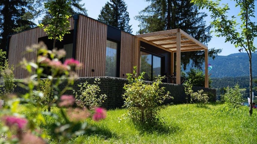 Moderne vakantiewoning met houten gevel, terras en omgeven door groen in een bosrijke omgeving