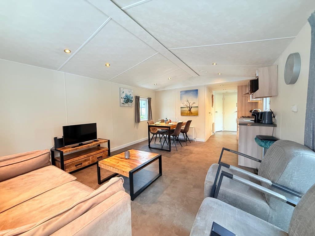 Ingerichte woonruimte met zithoek, eettafel en kitchenette in lichte kleuren en moderne inrichting