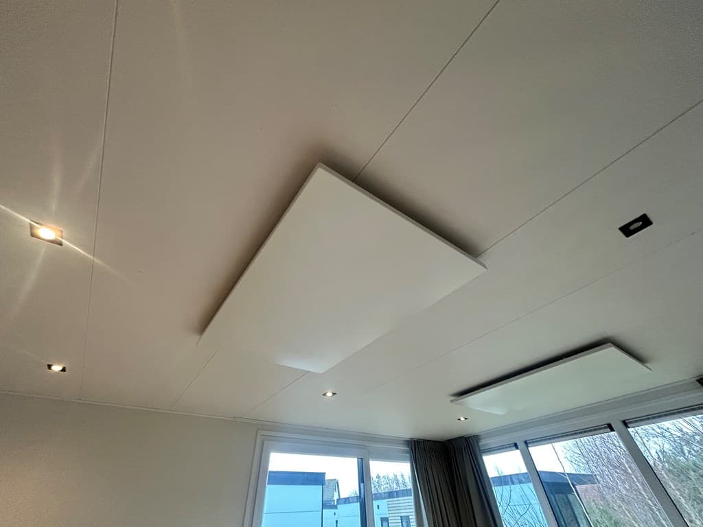 Verlichting en plafonddetails in moderne woning met grote ramen en zicht op buiten.