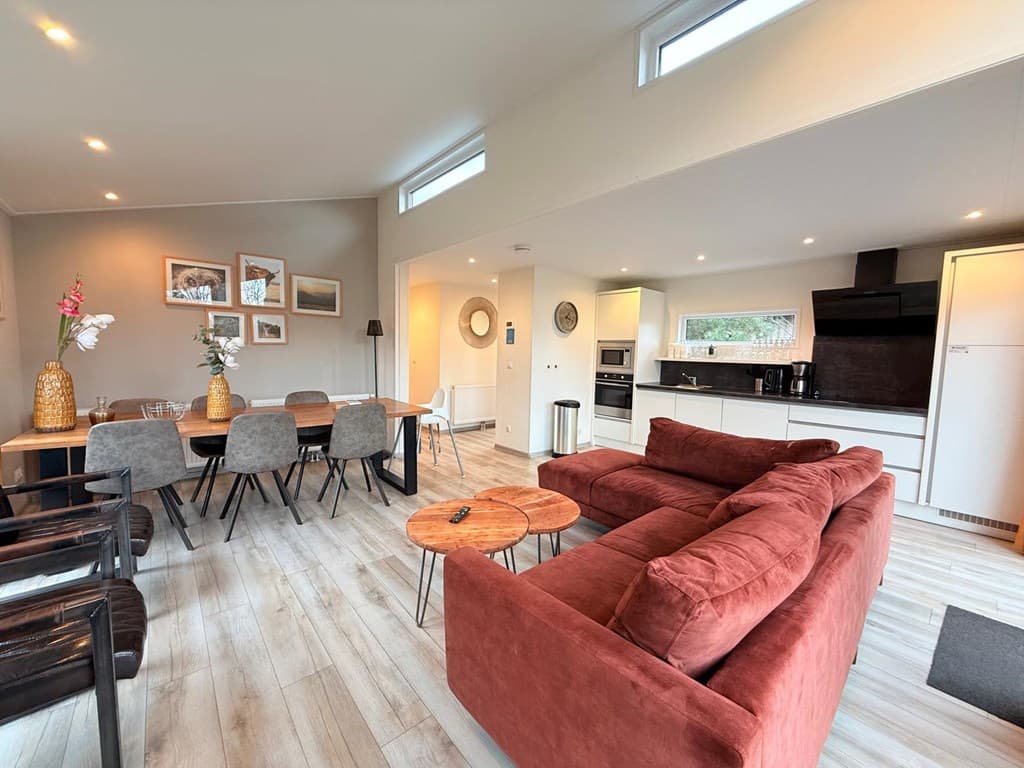 Modern interieur van een vakantiewoning met een zithoek, eettafel en keuken in EuroParcs Resort De Utrechtse Heuvelrug.