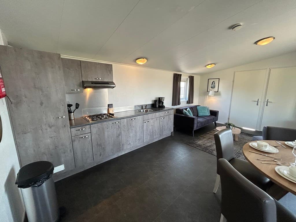 Moderne keuken met open woonkamer, eettafel, zithoek en grote ramen in EuroParcs Markermeer.