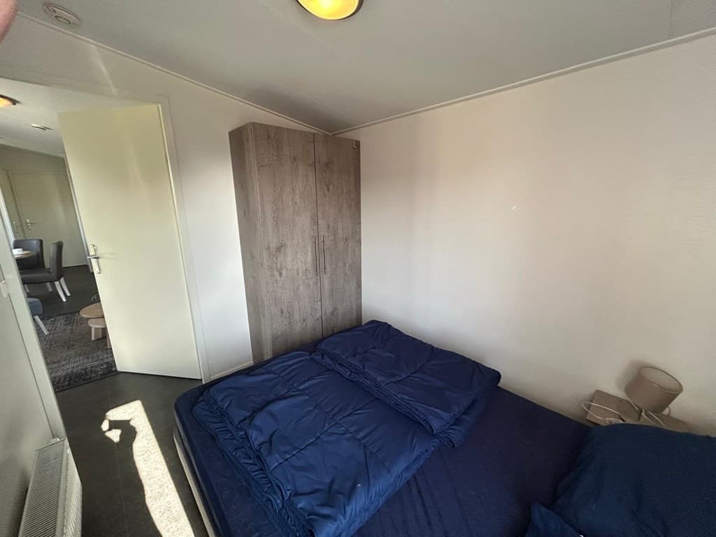 Slaapkamer met een lits-jumeaux bed en een kastenwand in EuroParcs Markermeer, Bovenkarspel