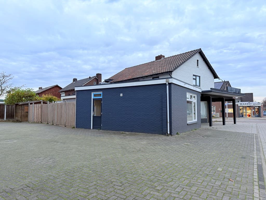 Woning met blauwe gevel en ruime parkeerplek aan de zijkant, gelegen in een stedelijke omgeving in Hengelo