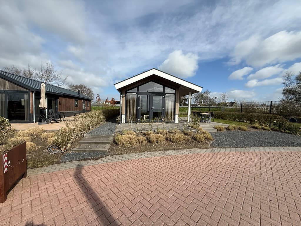Moderne vakantiewoning met glazen gevel, terras en een omliggende tuin in EuroParcs Markermeer, Bovenkarspel.