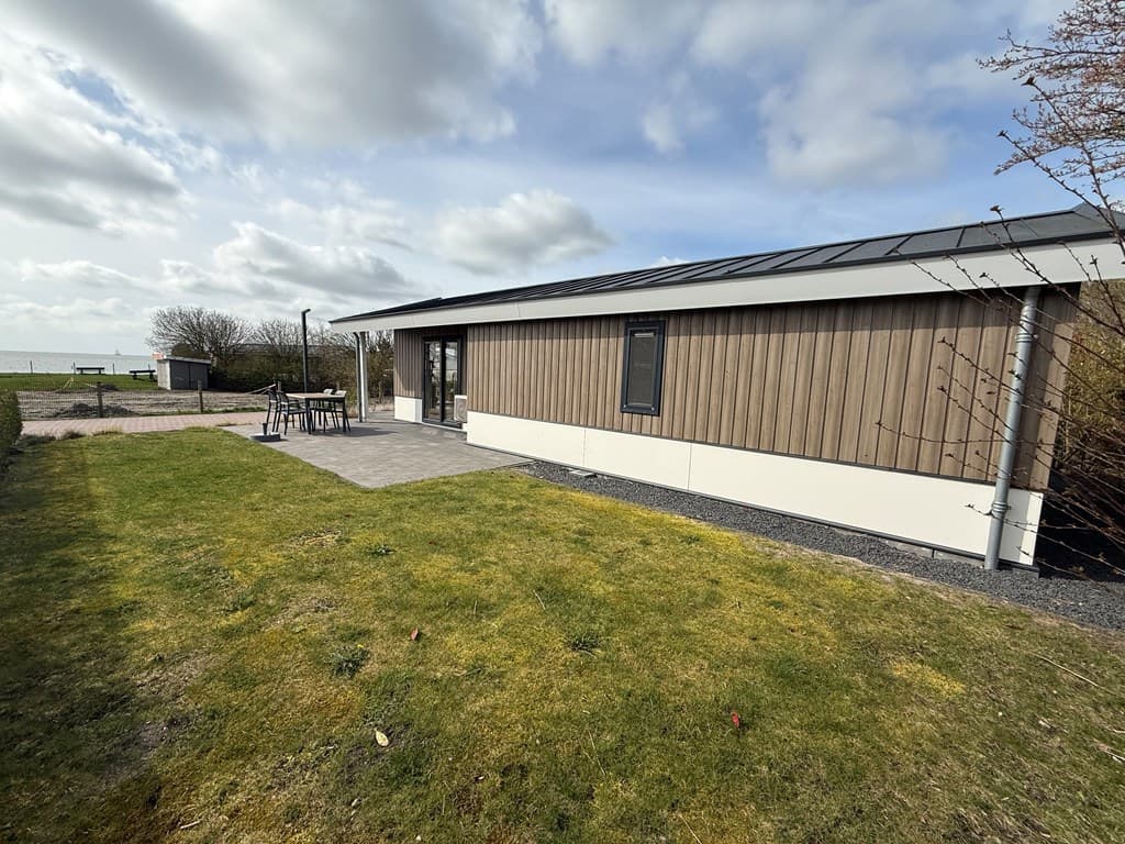 Moderne vakantiewoning met houten gevel, grasveld en terras bij EuroParcs Markermeer in Bovenkarspel.
