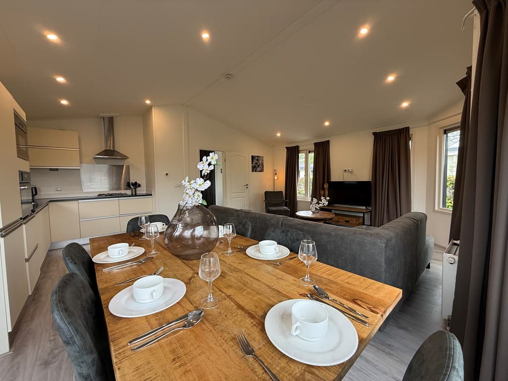 Hedendaagse woonkamer met eettafel, moderne keuken en zithoek bij EuroParcs De Biesbosch, Dordrecht.