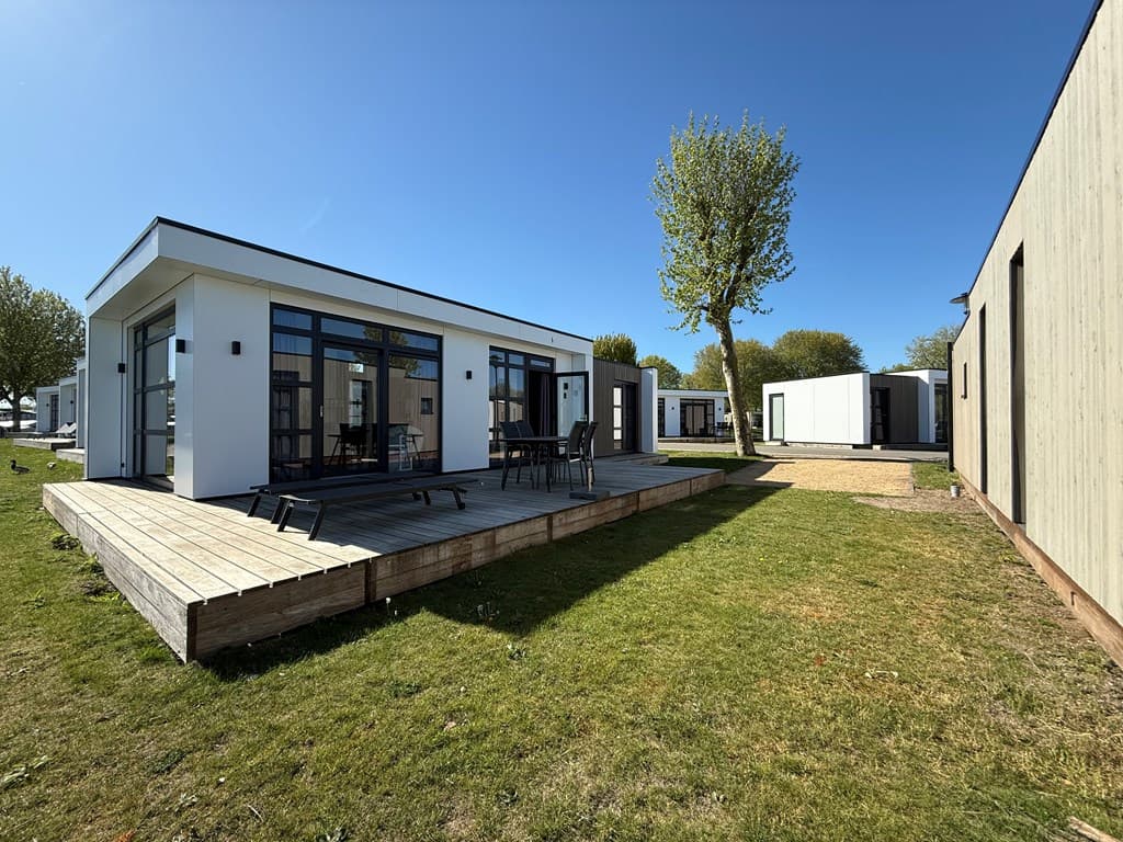 Moderne vakantiewoningen met houten terrassen en groene grasvelden in MarinaPark Bad Nederrijn, Maurik