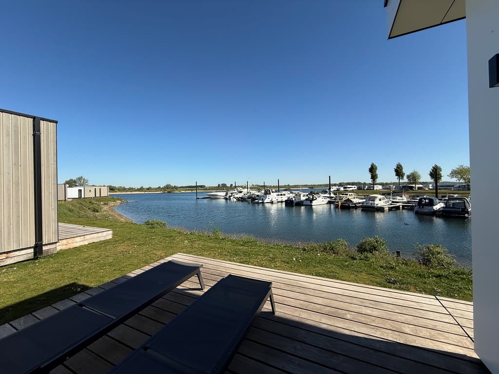 Uitzicht op de jachthaven met boten en water, omringd door groene gebieden en een blauwe lucht
