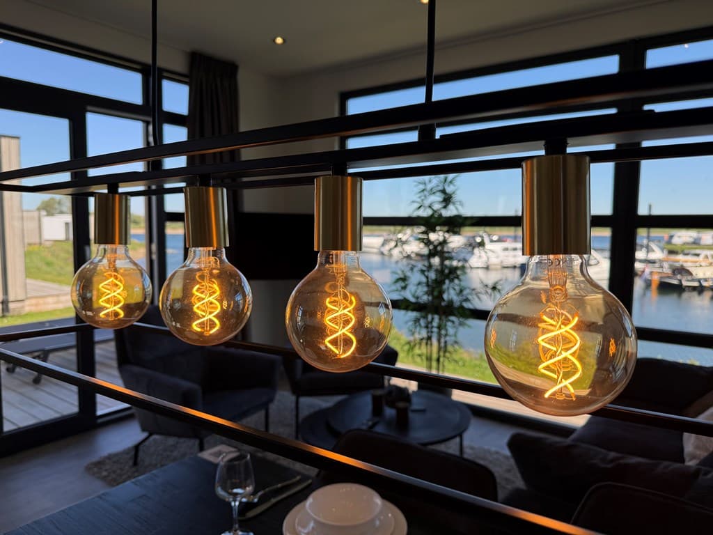 Lounge met modern verlichtingssysteem en uitzicht op het water met boten in MarinaPark Bad Nederrijn