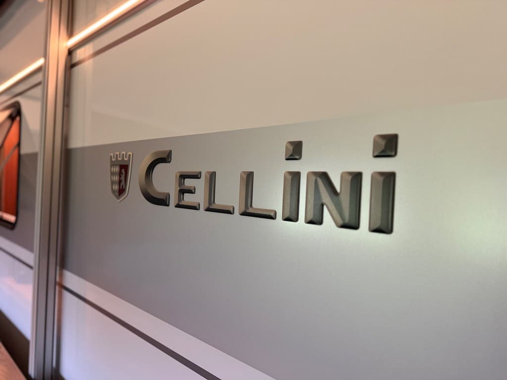 Tekst op een caravan met het logo en de naam "Cellini" duidelijk zichtbaar op de zijkant.