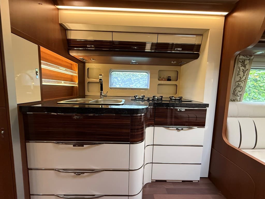 Moderne keuken met donker blad, gasfornuis, kastruimte en grote ramen voor natuurlijk licht