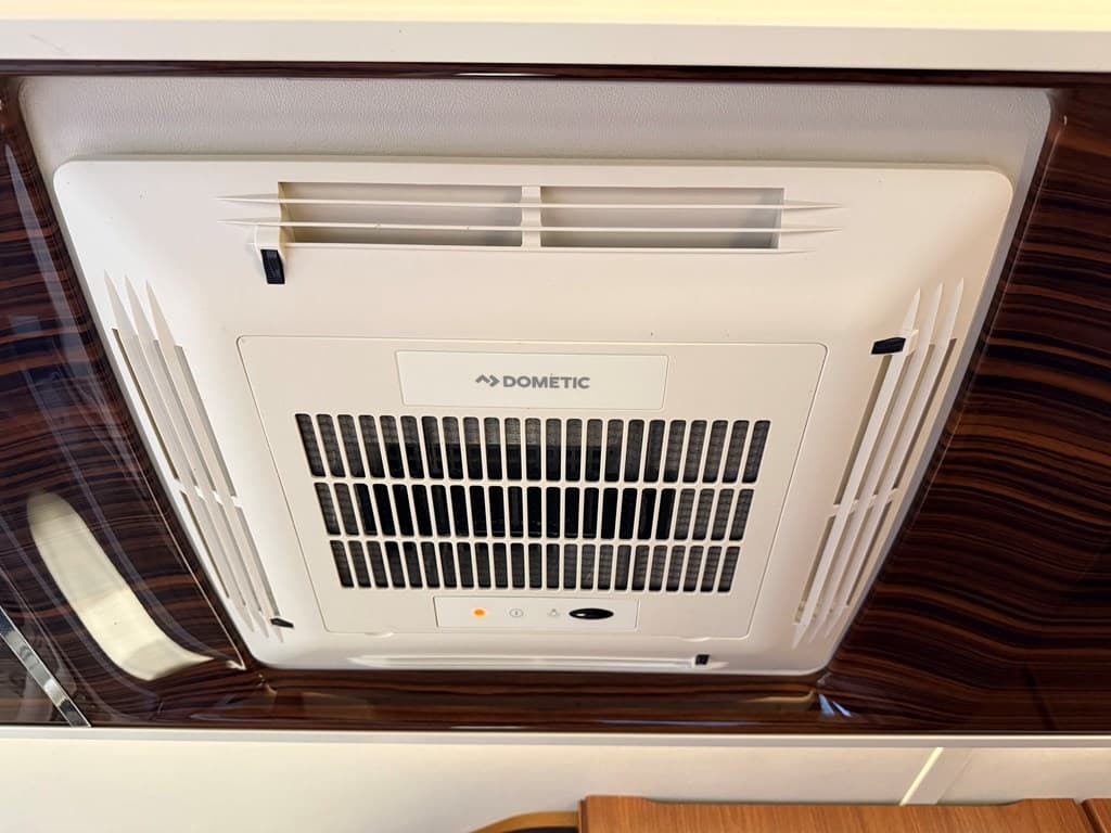 Luchtverhittersysteem aan het plafond met een witte afwerking en ventilatieroosters