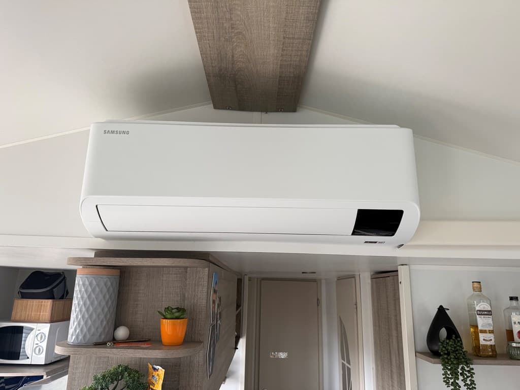 Luchtbehandelingssysteem aan het plafond in een moderne woonruimte met houten details en decoratieve elementen.