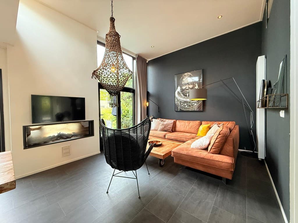 Moderne woonkamer met een grote bank, open haard en stijlvolle decoratie aan de muur