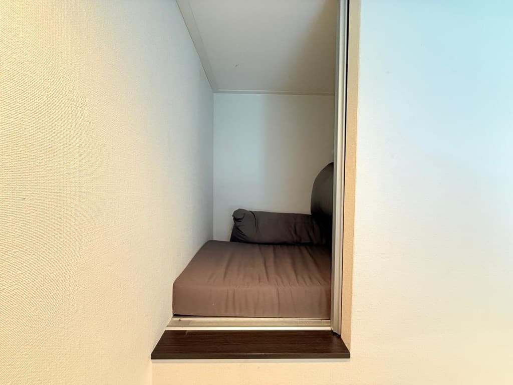 Sfeervolle nook met een comfortabel kussen en een lichte wandafwerking.