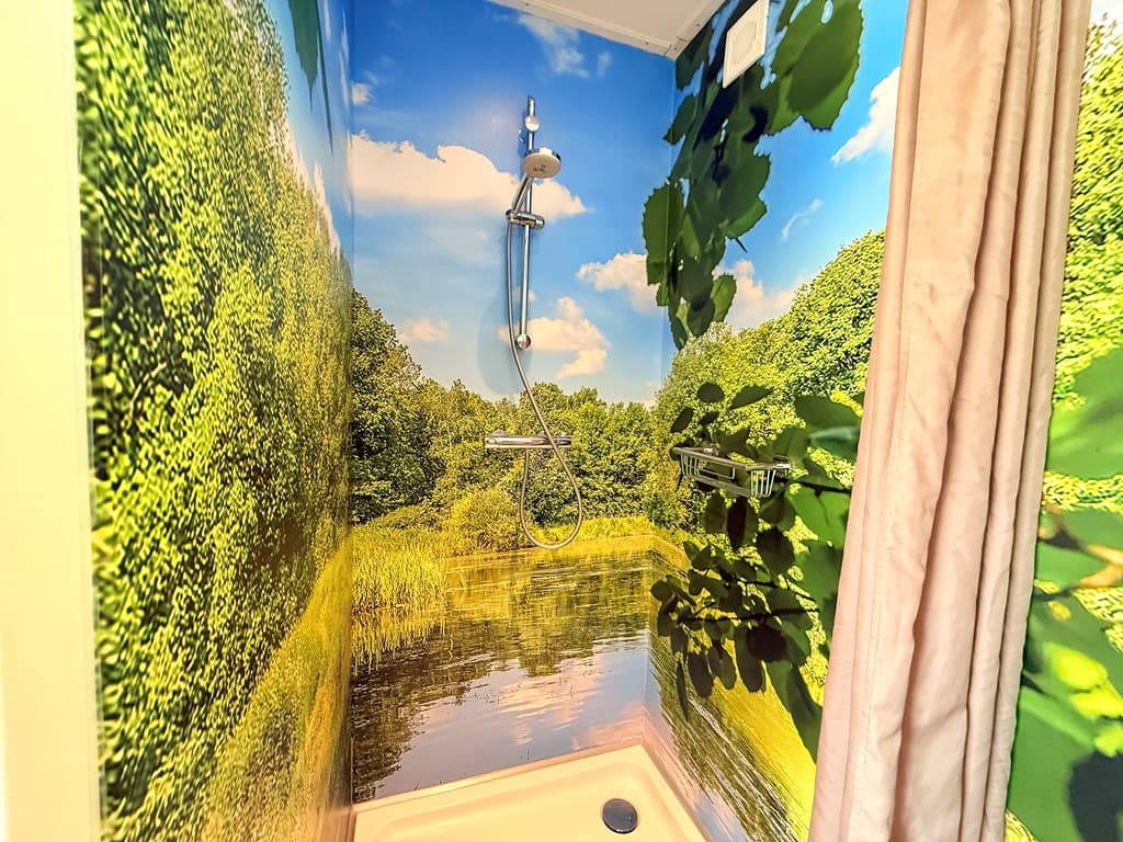 Douche met groene natuurwanddecoratie en een regenstraal douchekop in een lichte omgeving