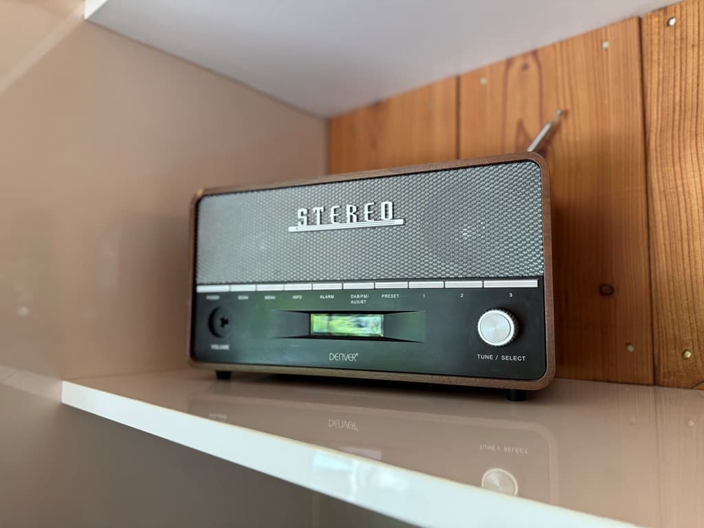 Vintage stereo radio op een witte plank met een houten achterwand
