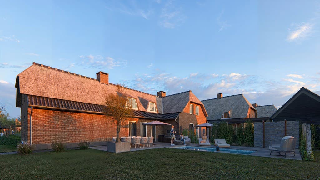 Twee woningen met rieten daken, een zwembad en zitplekken in de tuin bij zonsondergang.